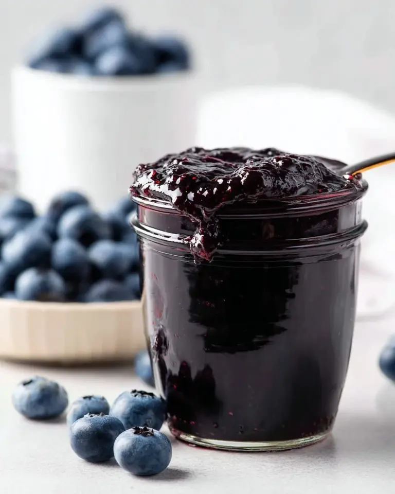 Homemade Bourbon Blueberry Jam in a jar, perfect for breakfast or desserts.