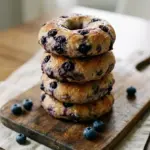 Freshly baked homemade blueberry bagels on a cooling rack